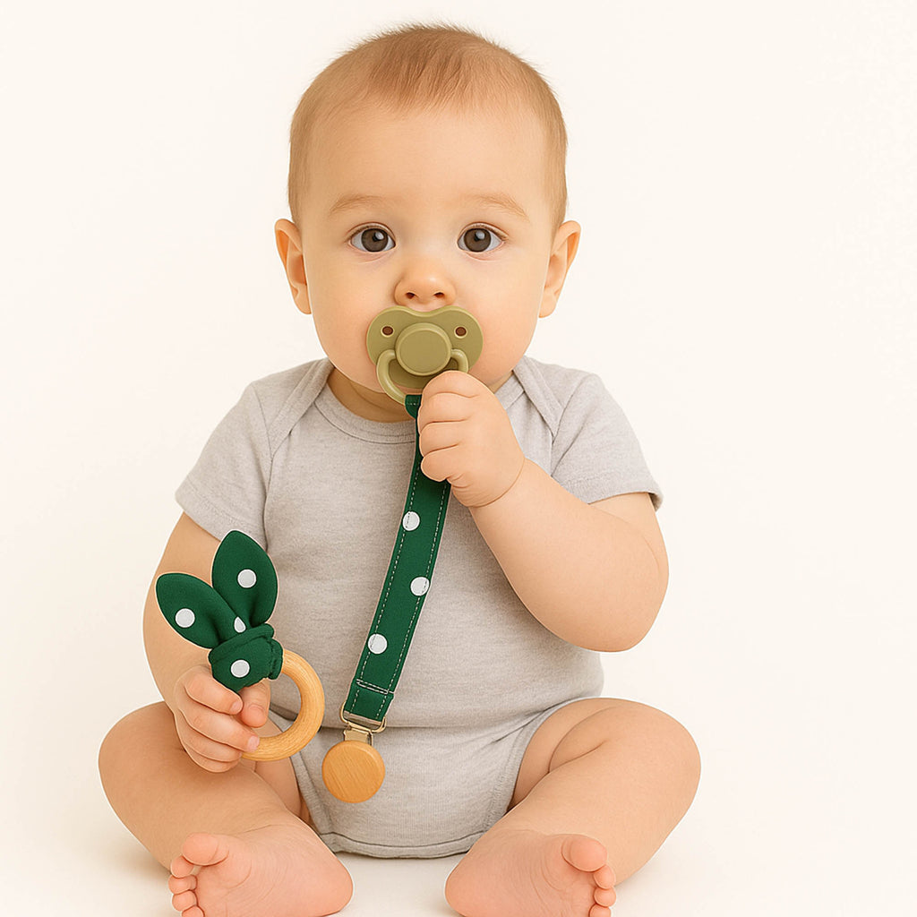 Μωρό κρατά υφασμάτινο μασιτικό και κλιπ πιπίλας πράσινο πουά με ξύλινο κούμπωμα